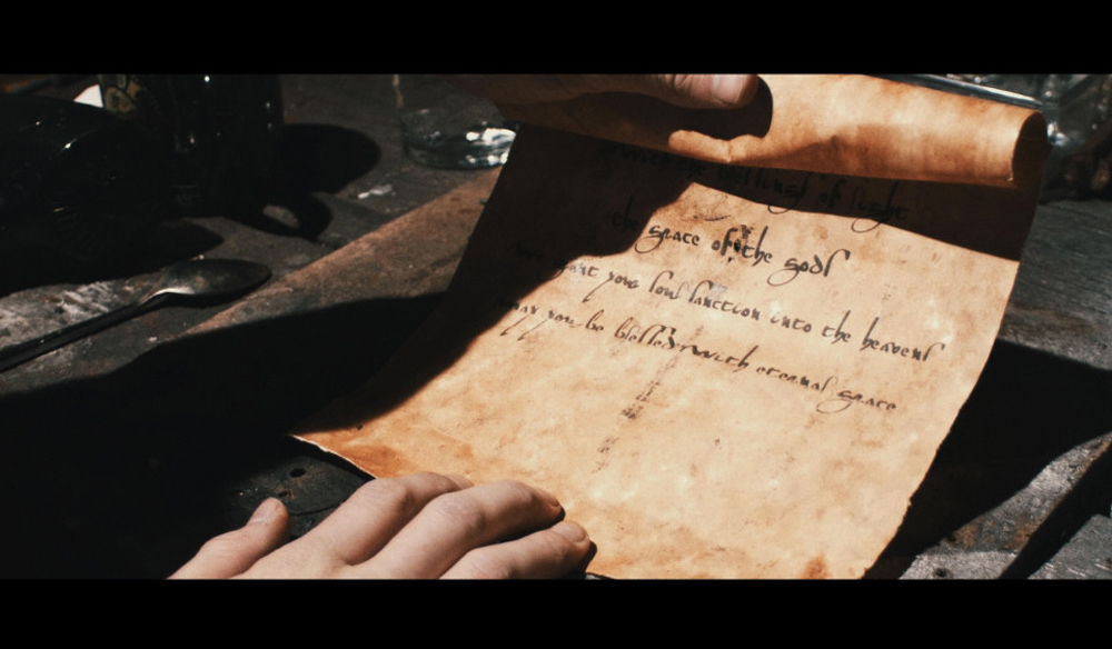 A prop of a scroll of parchment paper with ancient-like handwriting.  