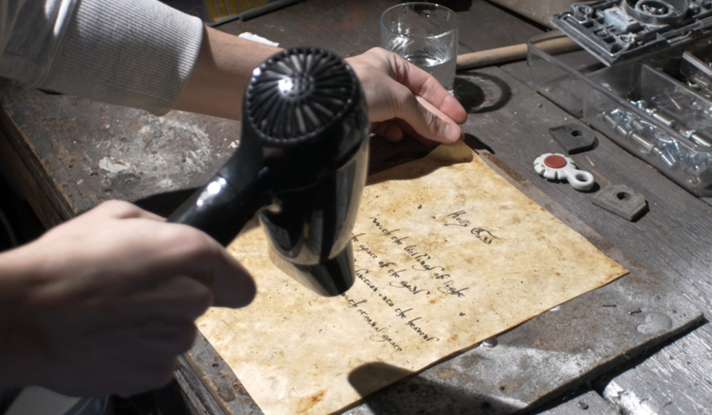 A person hair drying the coffee-stained parchment paper 