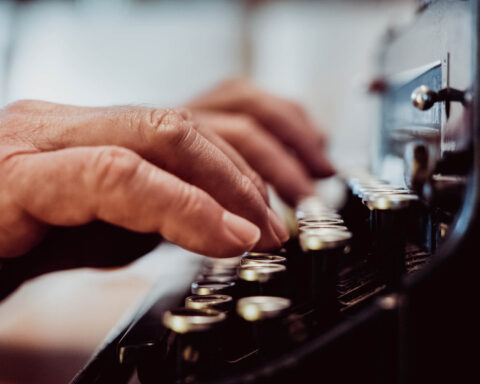 A man typing on a typewriter.