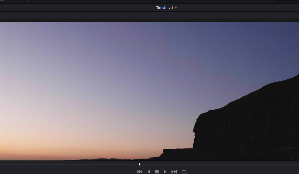 Screenshot of sunset landscape with the silhouette of a cliff.