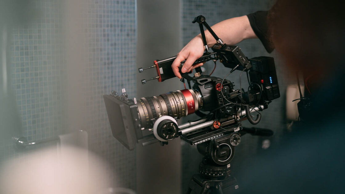 A cinema camera on set, with a magic arm holding a monitor