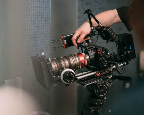 A cinema camera on set, with a magic arm holding a monitor